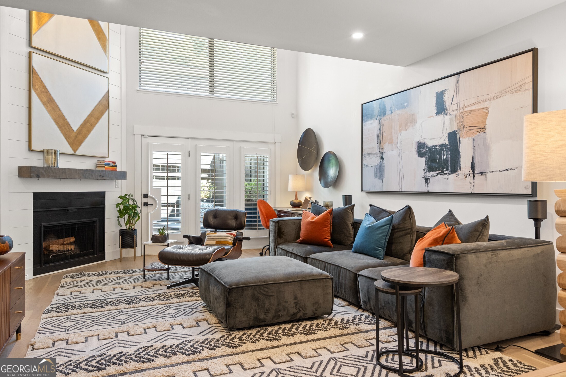 a living room with furniture a fireplace and a large window