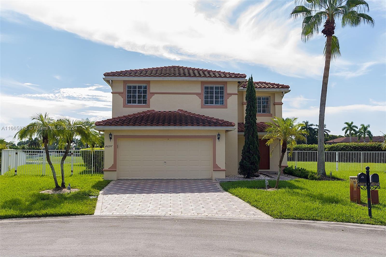 a front view of a house with a garden and a garage