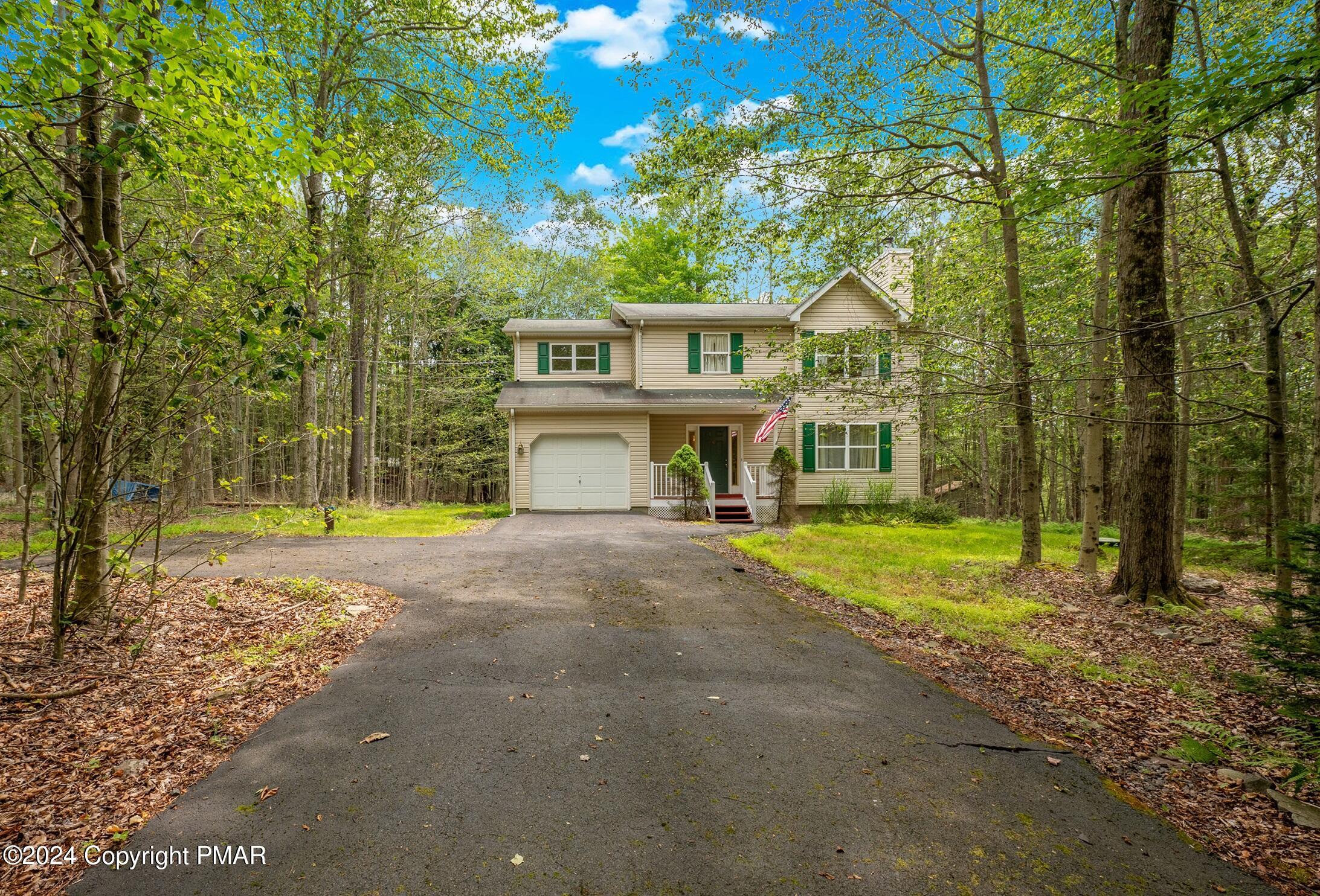 a view of a house with backyard and trees