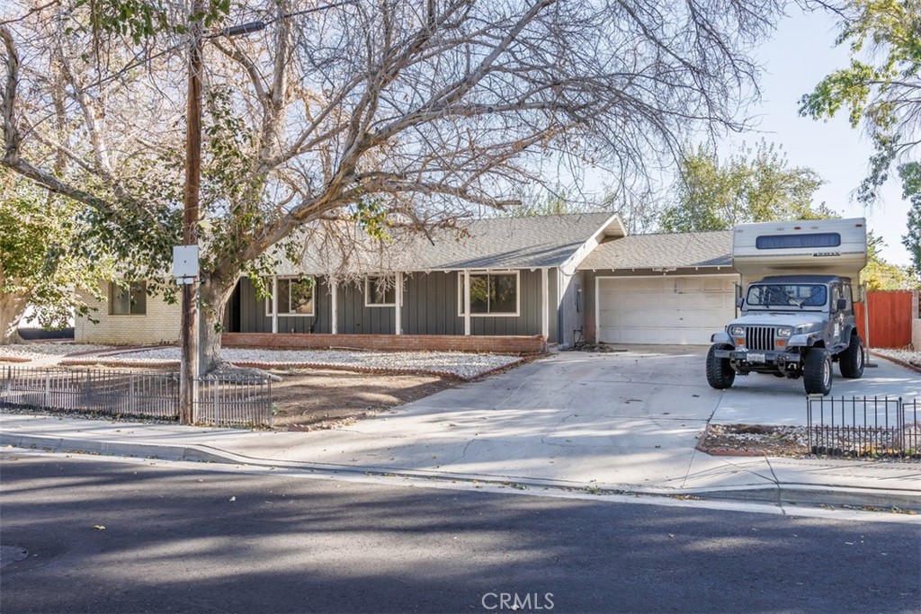 a view of a house with street that has a tree