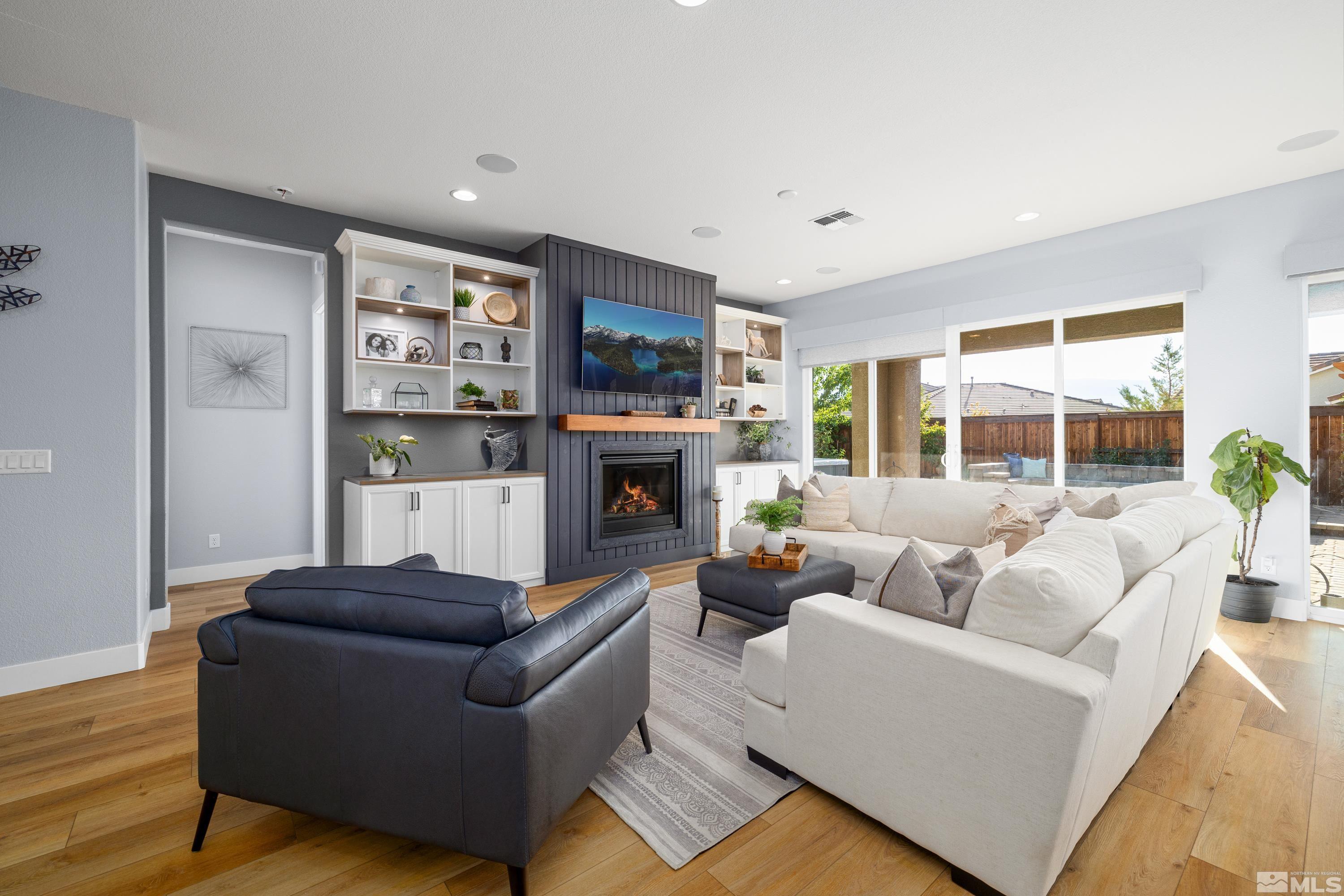 a living room with furniture a large window and a fireplace