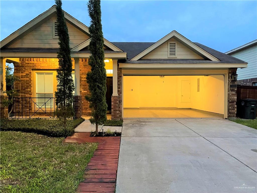 View of front of property with a garage and a front lawn