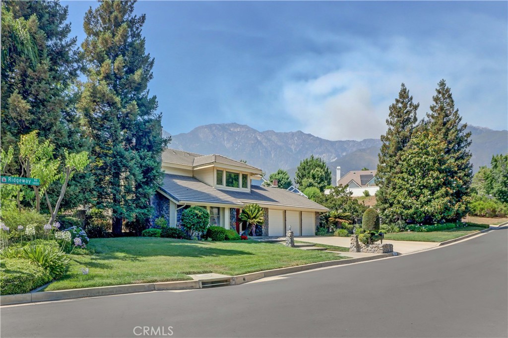 a view of a big house with a big yard and large trees