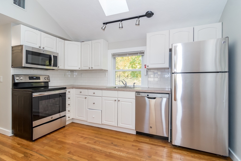 a kitchen with stainless steel appliances a refrigerator sink and microwave