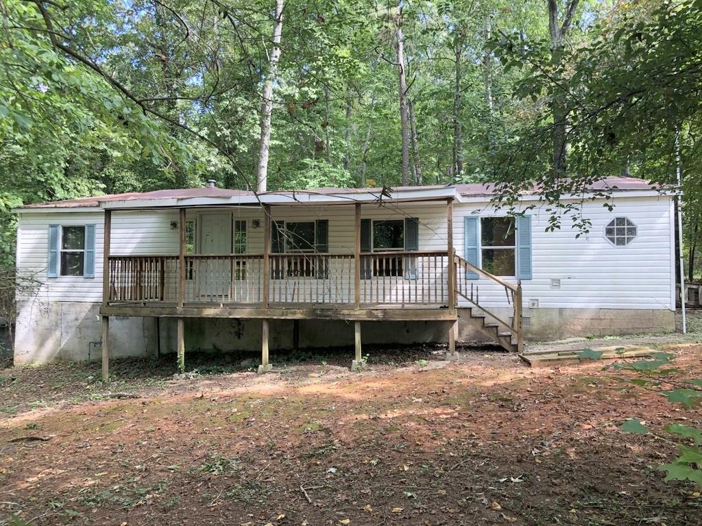 a view of a house with a yard deck and a patio