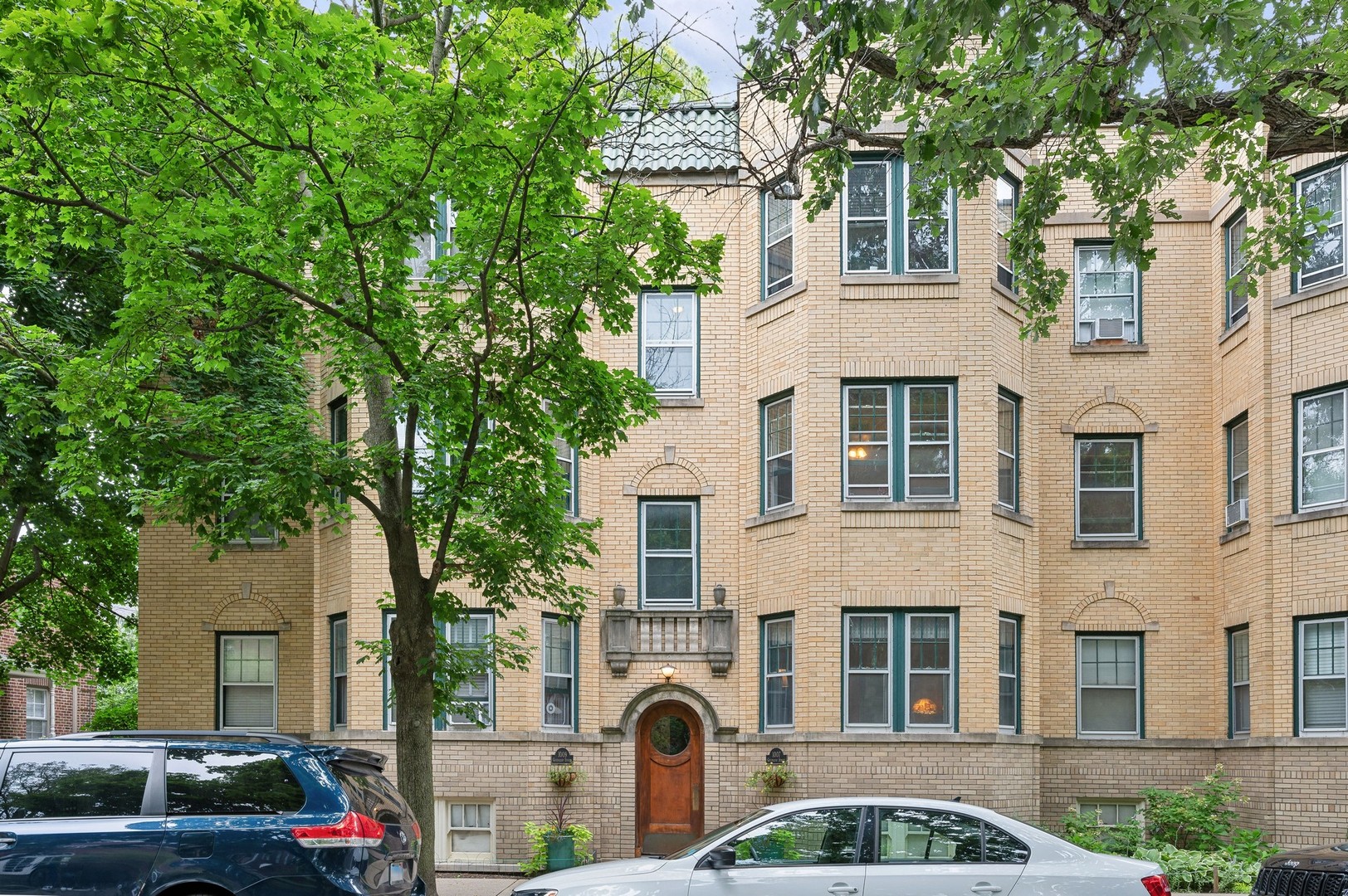 a front view of residential houses with cars parked