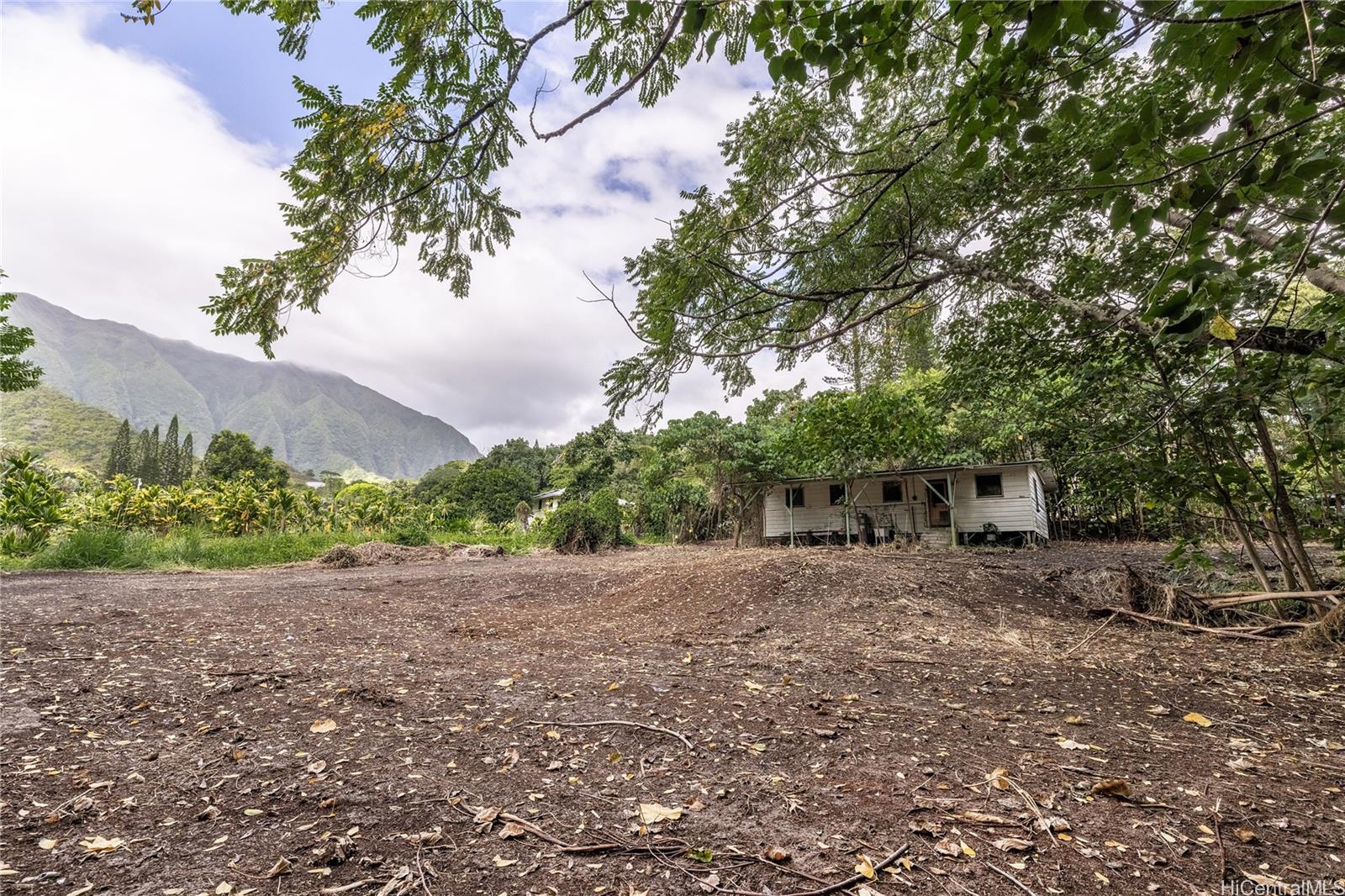 a view of a dirt road with a building in the background