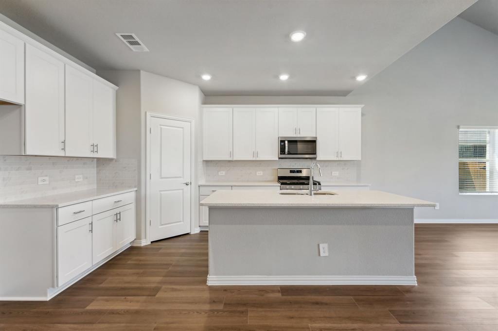 a kitchen with stainless steel appliances granite countertop a sink stove and wooden floor