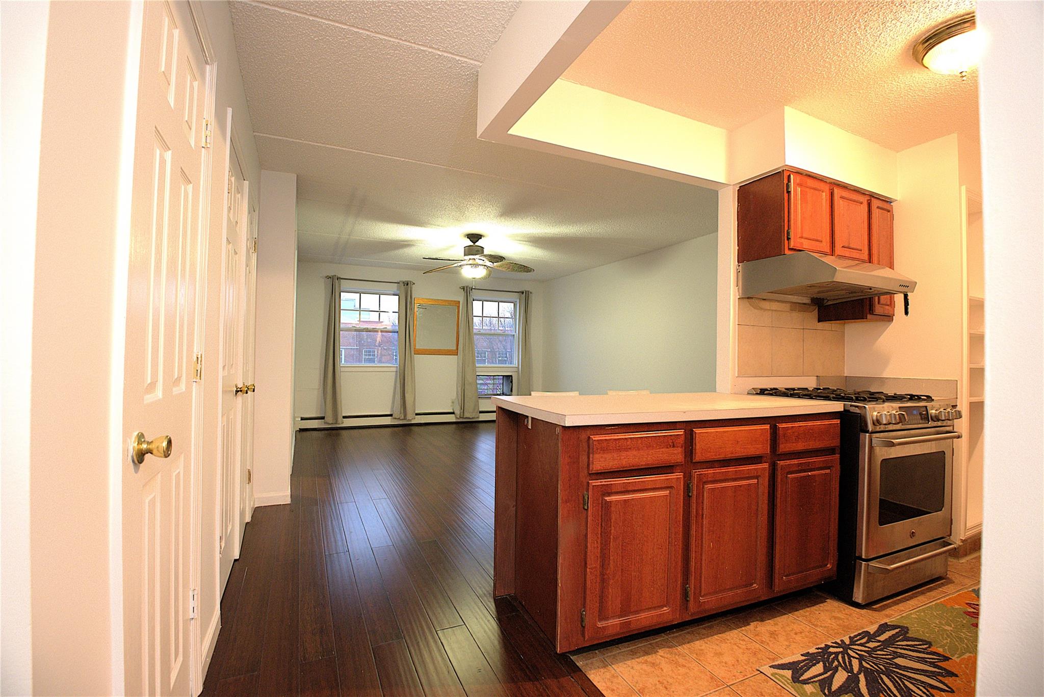 Kitchen with high end range, light hardwood / wood-style flooring, ceiling fan, a textured ceiling, and kitchen peninsula