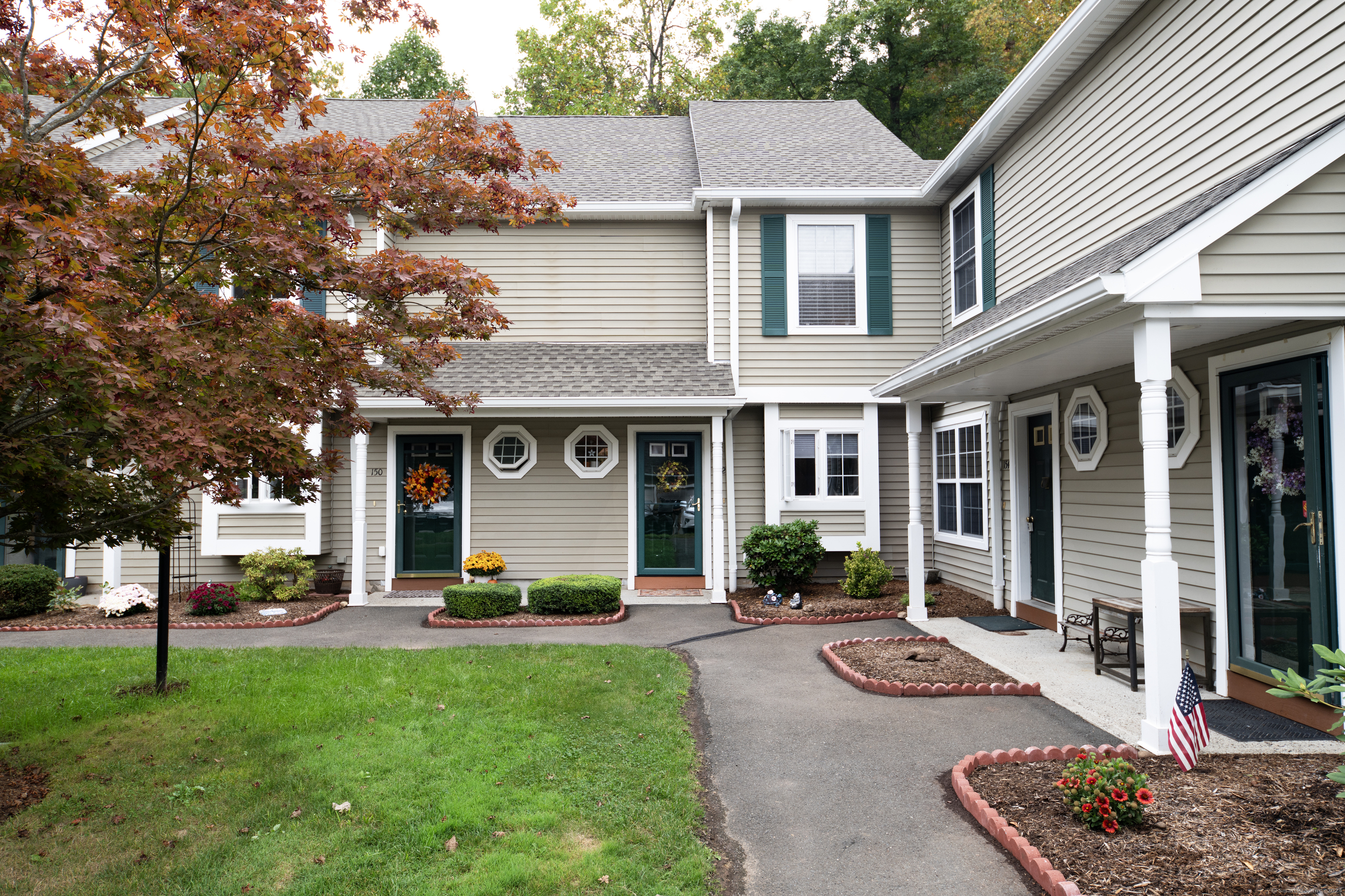 a front view of a house with a yard and trees