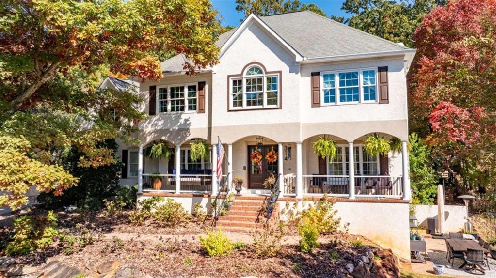 front view of a house with a large window and potted plants