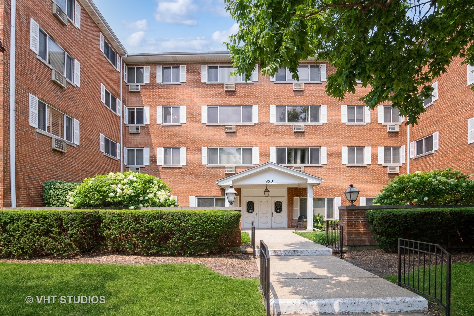 a front view of a residential apartment building with a yard