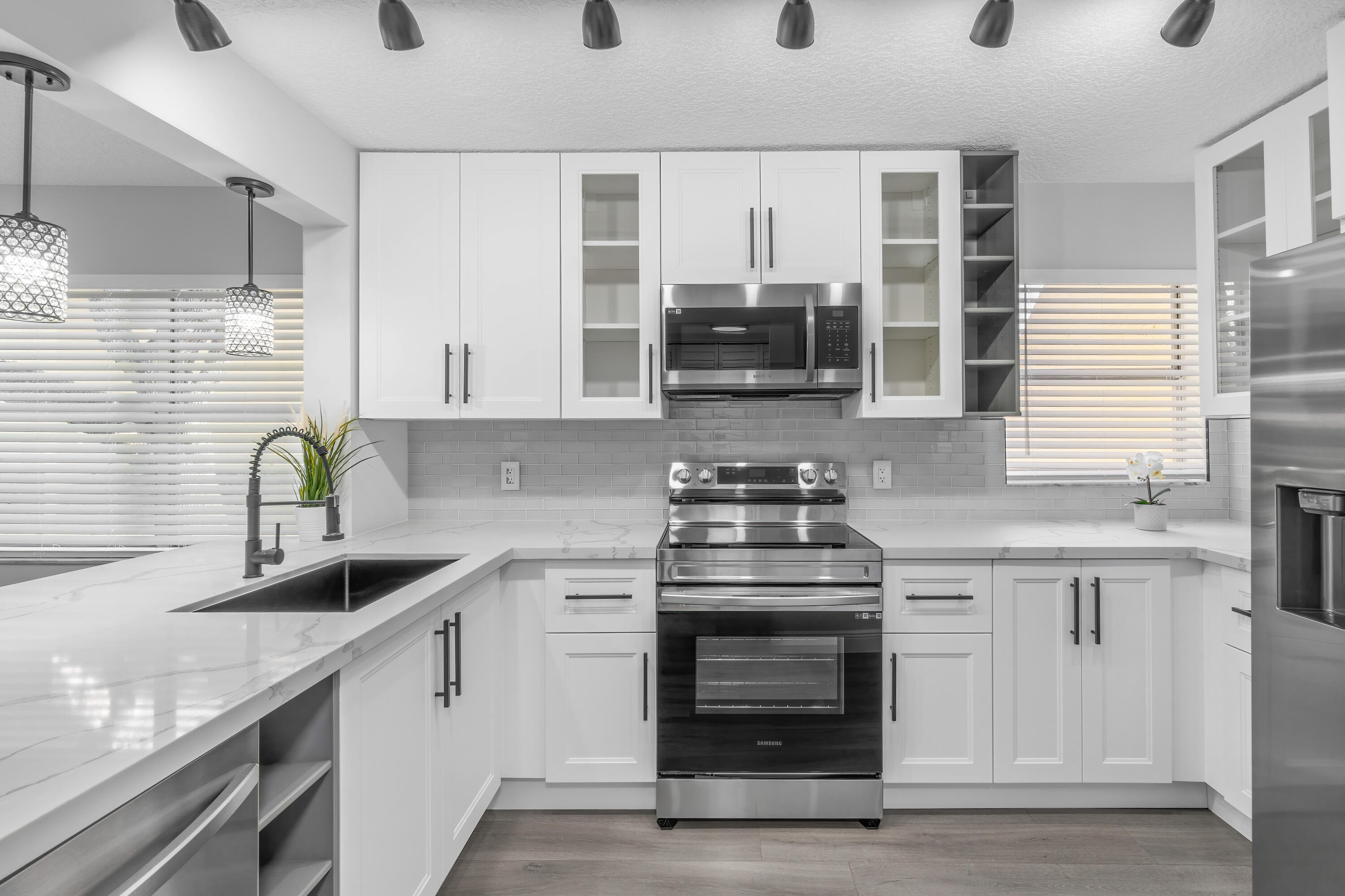 a kitchen with kitchen island granite countertop a sink stainless steel appliances and cabinets