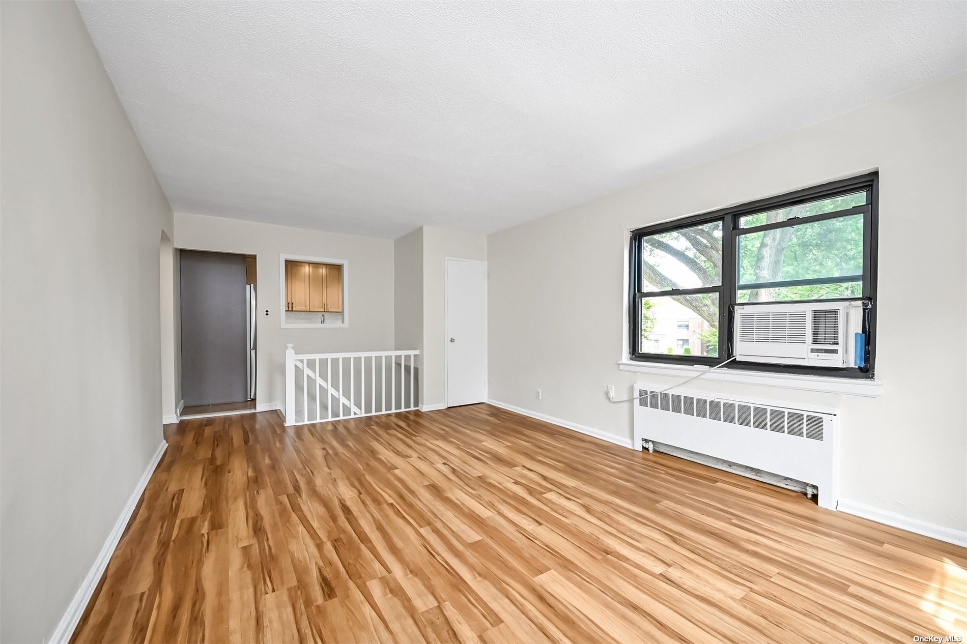 a view of a bedroom with wooden floor and windows