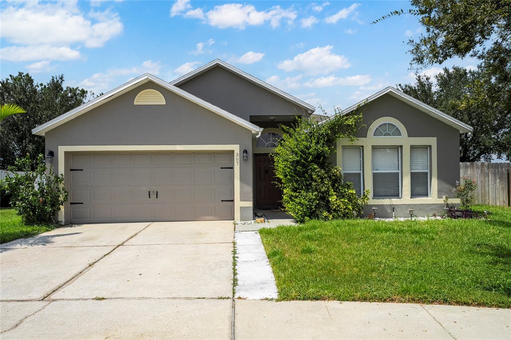 a front view of a house with a yard and garage