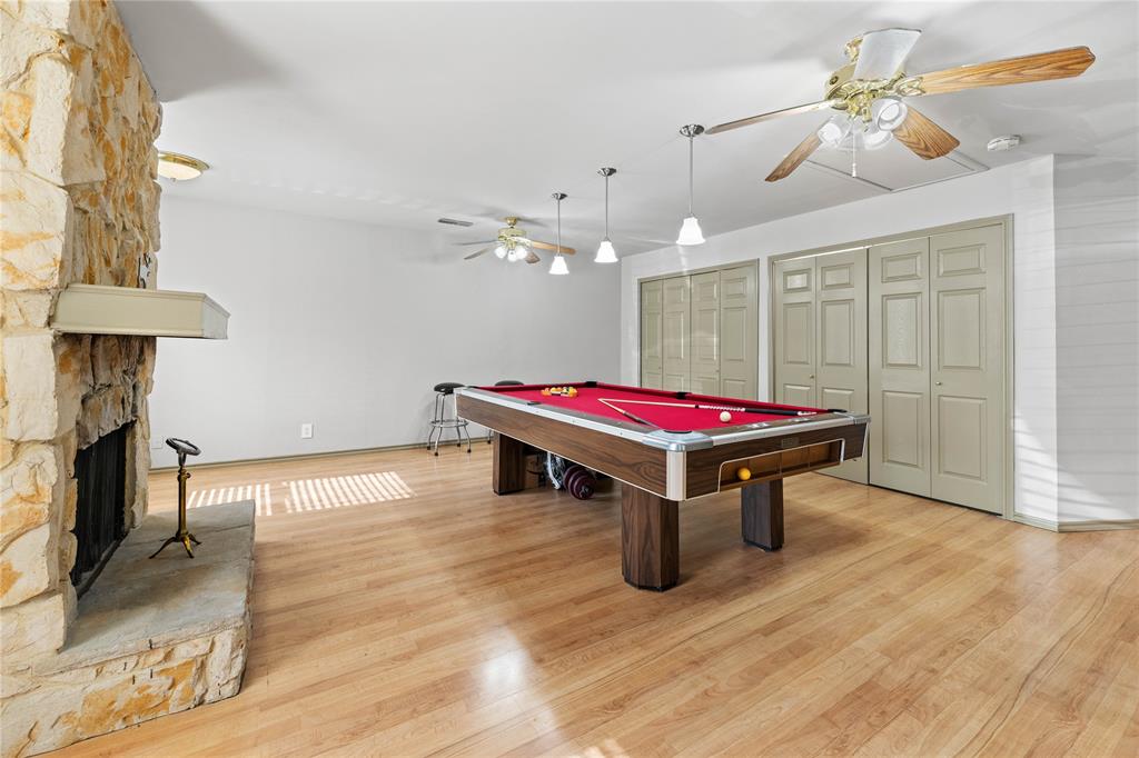 a room with pool table and wooden floor