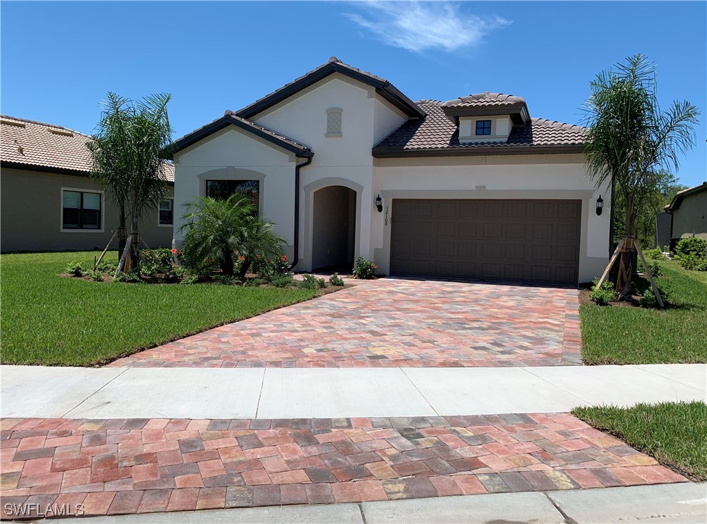 a front view of a house with a yard and a garage