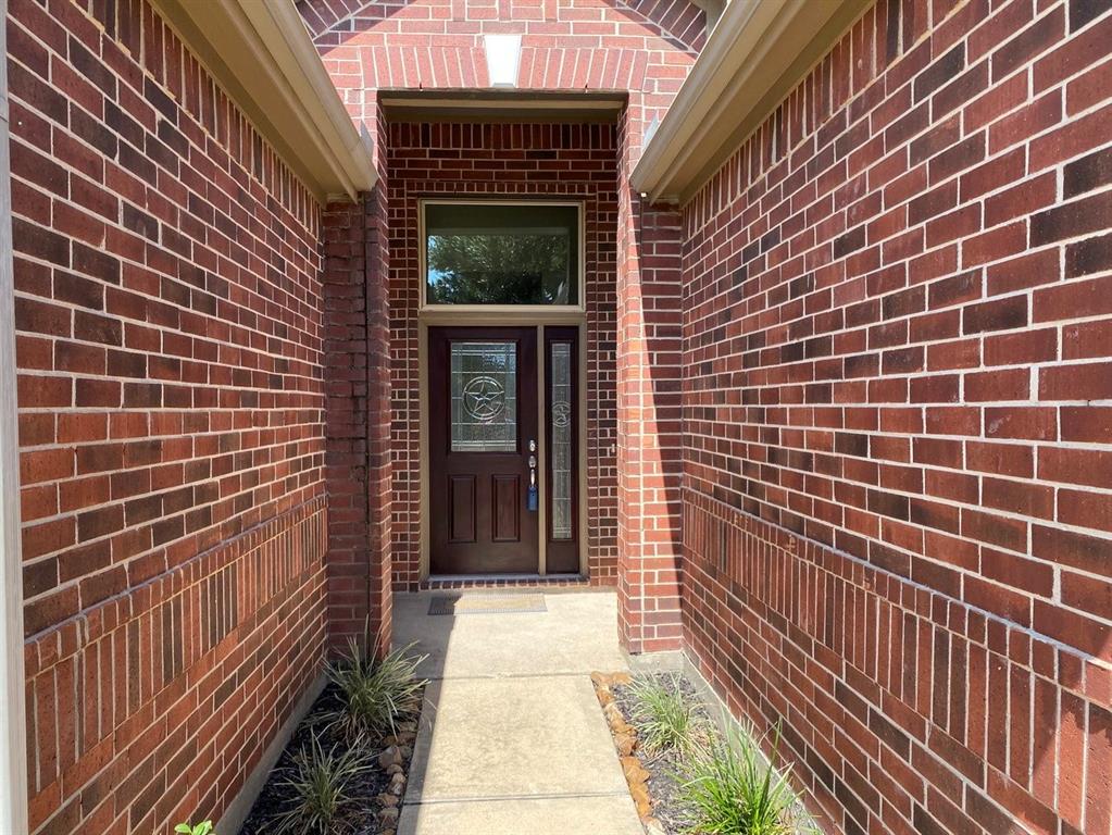 a view of a brick house with a door and wooden floor