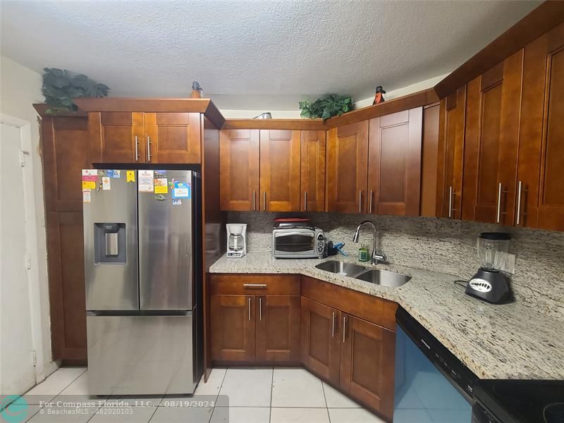 a kitchen with a sink refrigerator and cabinets