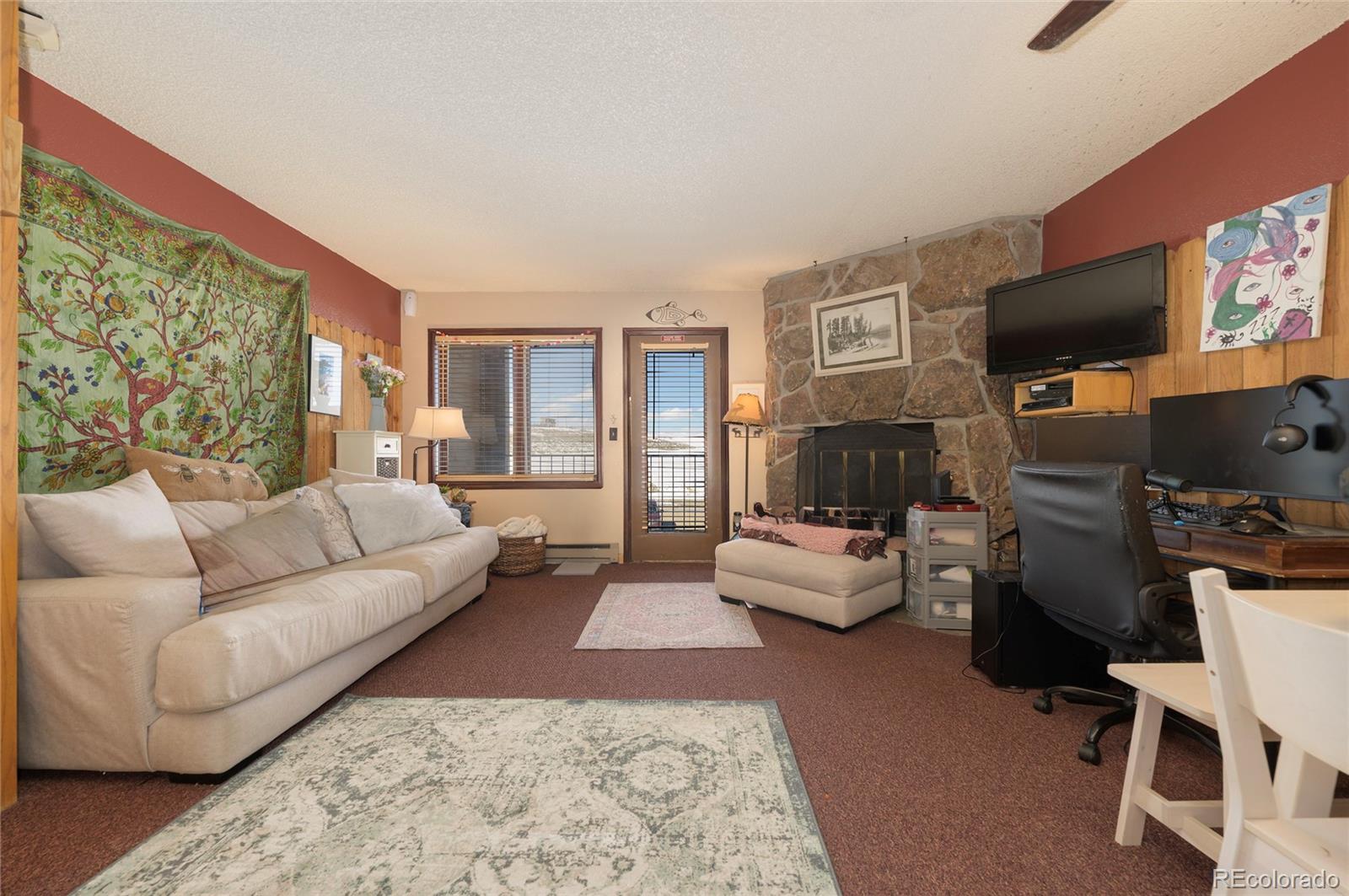 a living room with furniture a flat screen tv and a fireplace