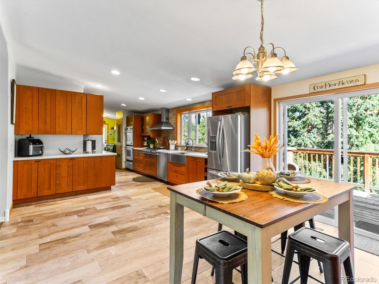 a view of a dining room with furniture a chandelier and wooden floor