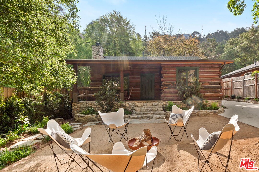 a view of backyard with outdoor seating and trees