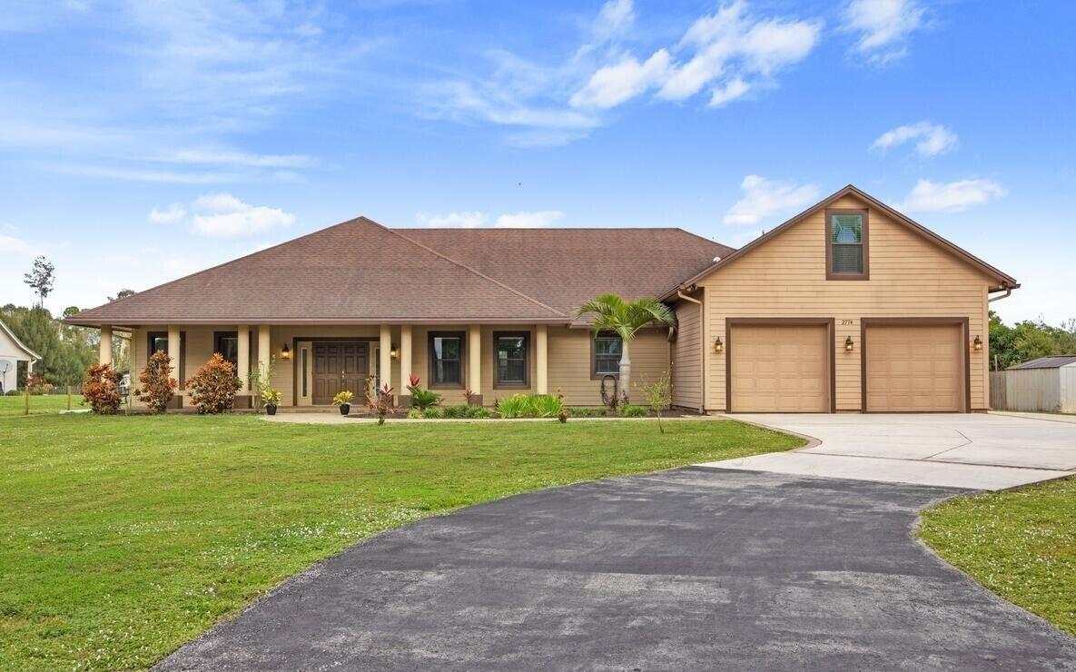 a front view of a house with a yard and trees