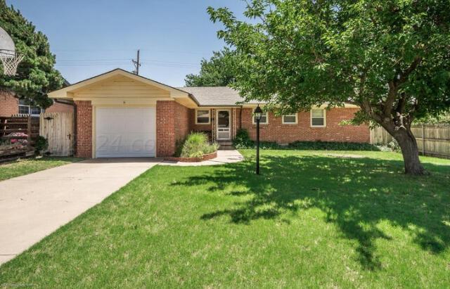 a front view of a house with yard and green space