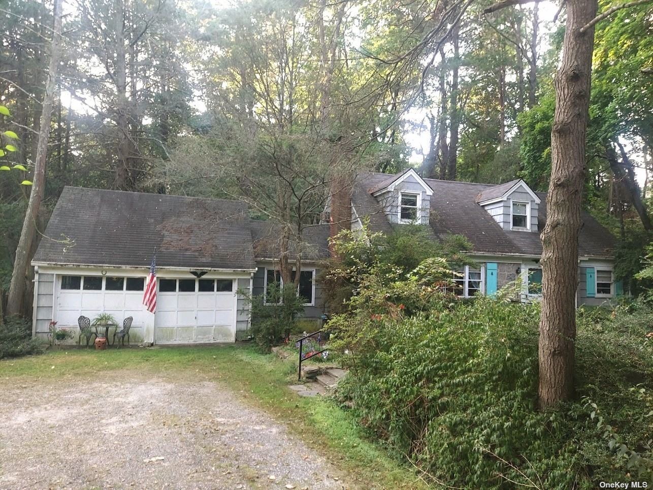 a front view of house with yard and trees in the background