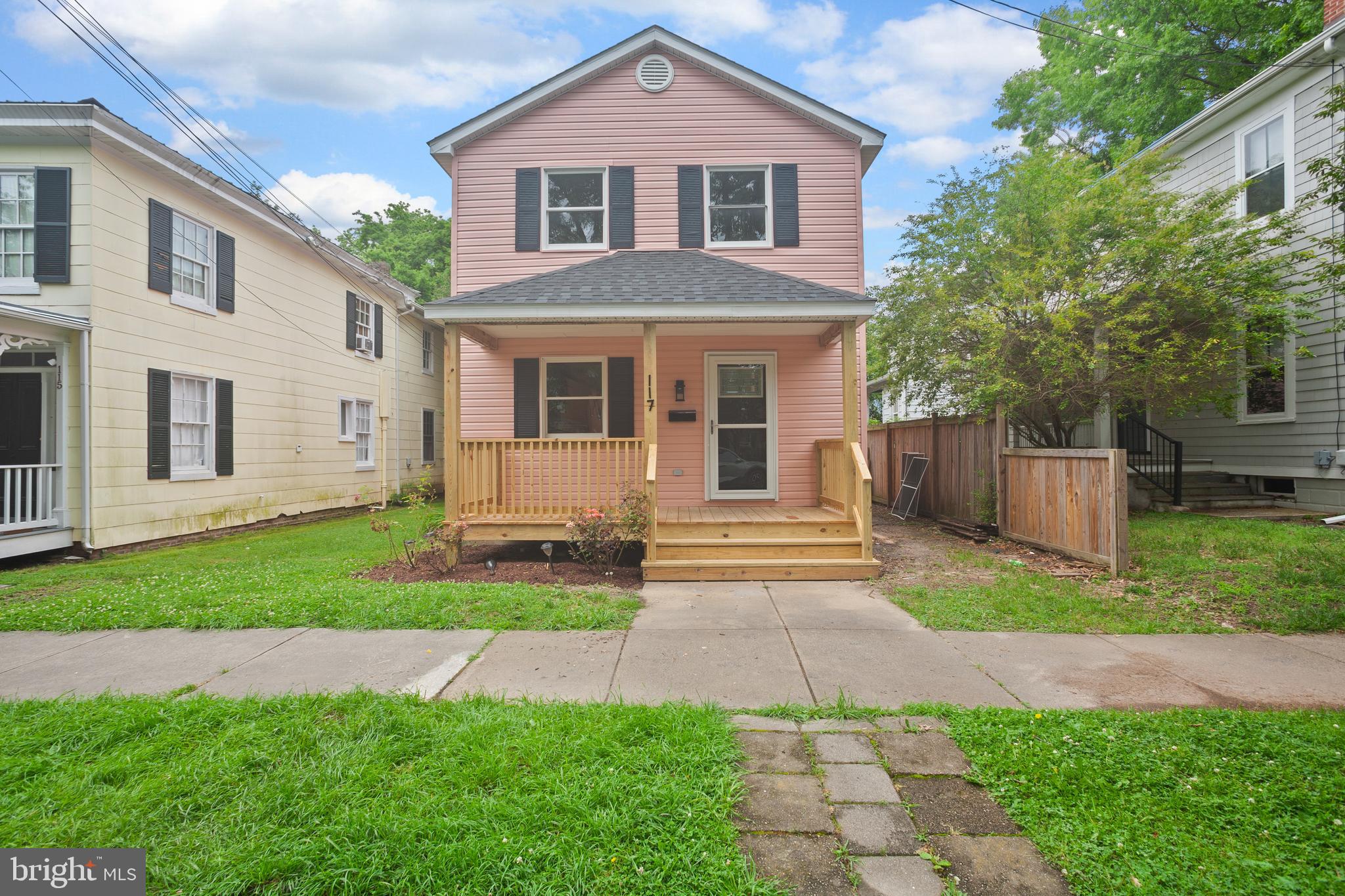 a front view of a house with a yard and fence