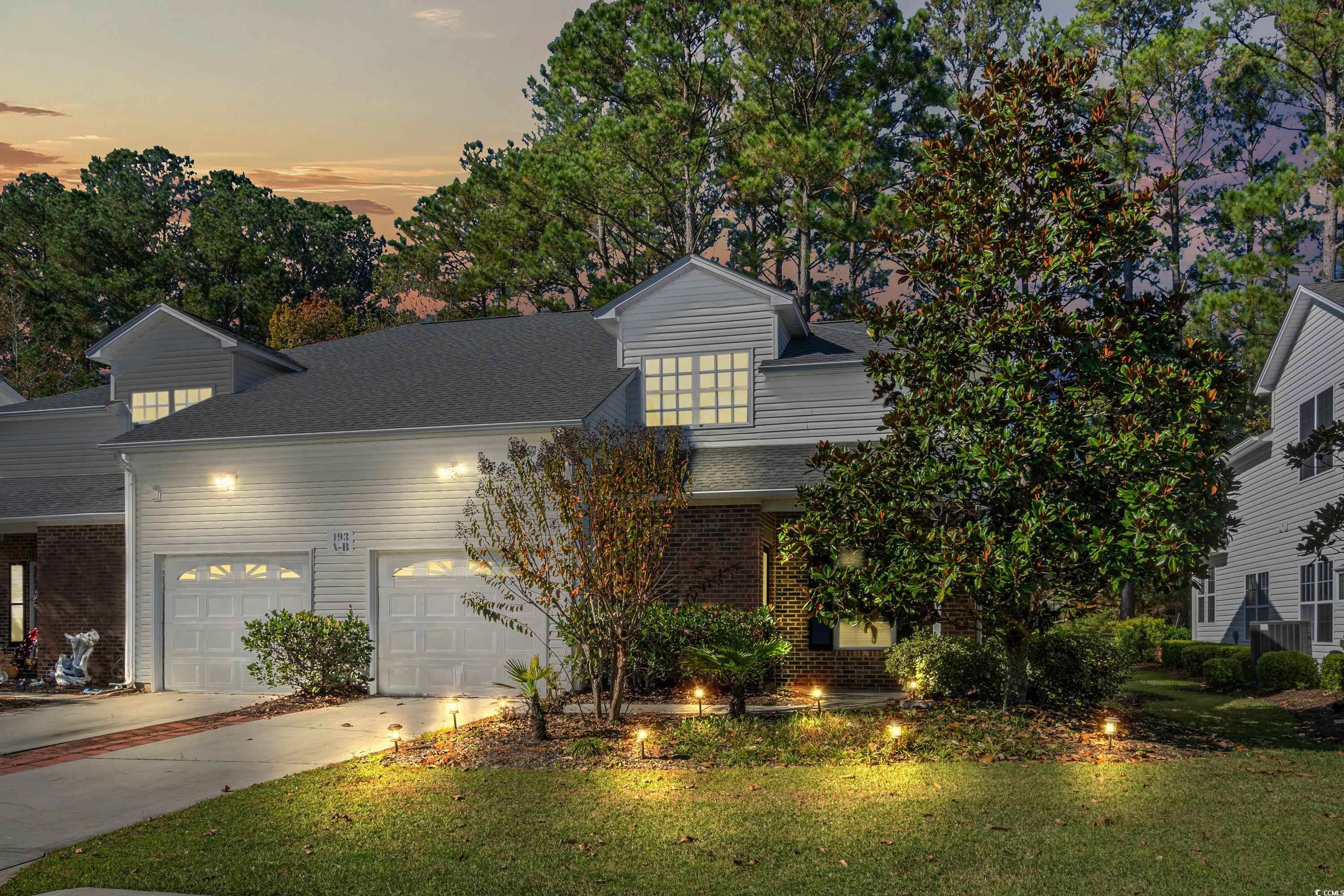 View of front of home featuring a garage and a law