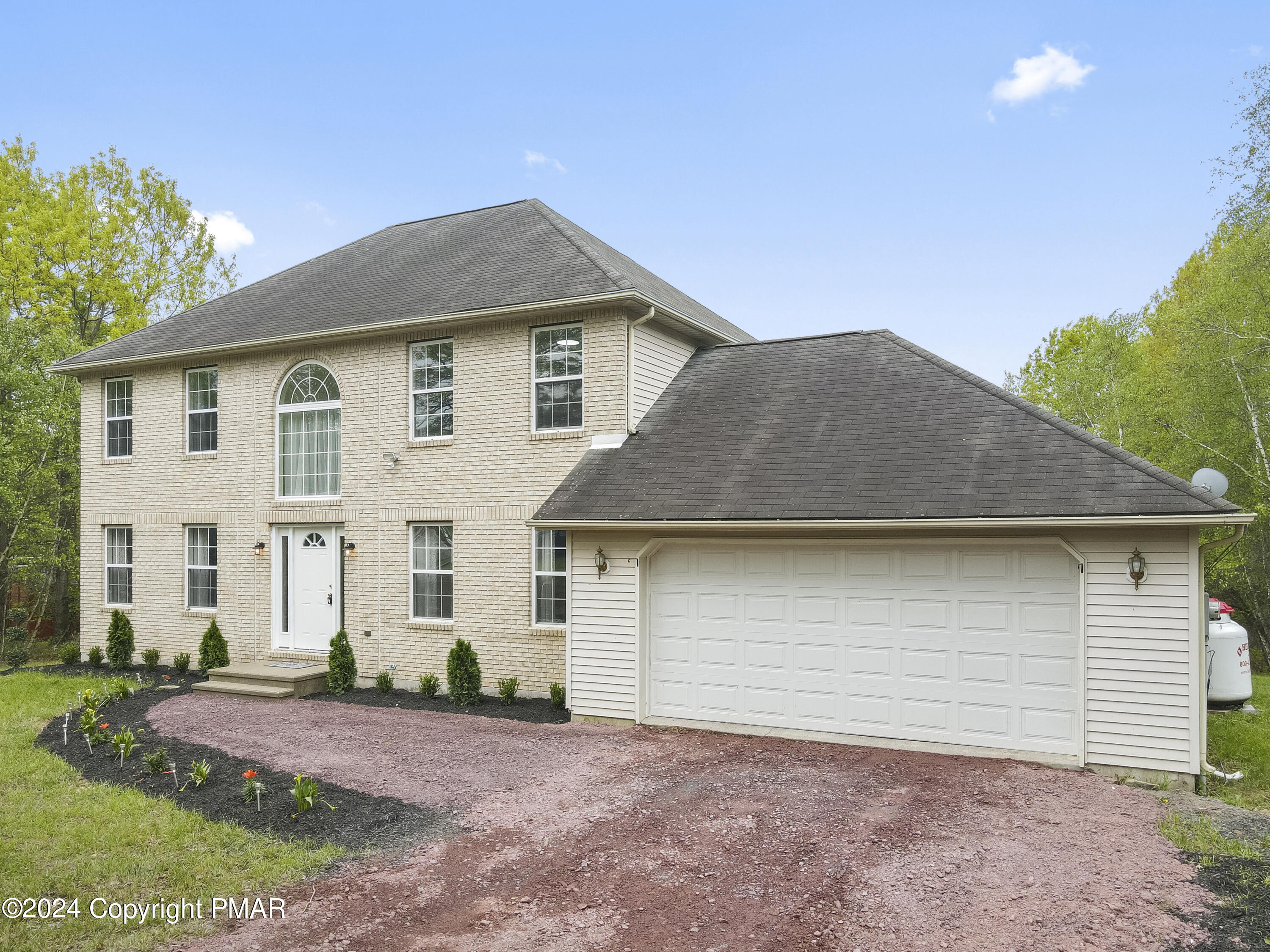 a front view of a house with a yard and garage