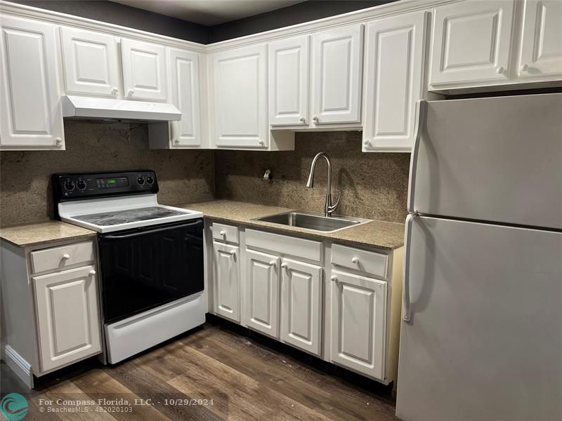 a kitchen with stainless steel appliances granite countertop white cabinets sink and granite counter tops