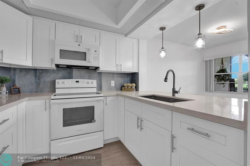 a kitchen with white cabinets and white appliances