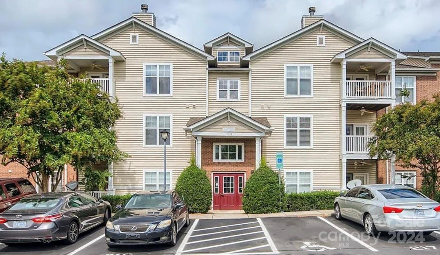 a front view of a house with cars parked