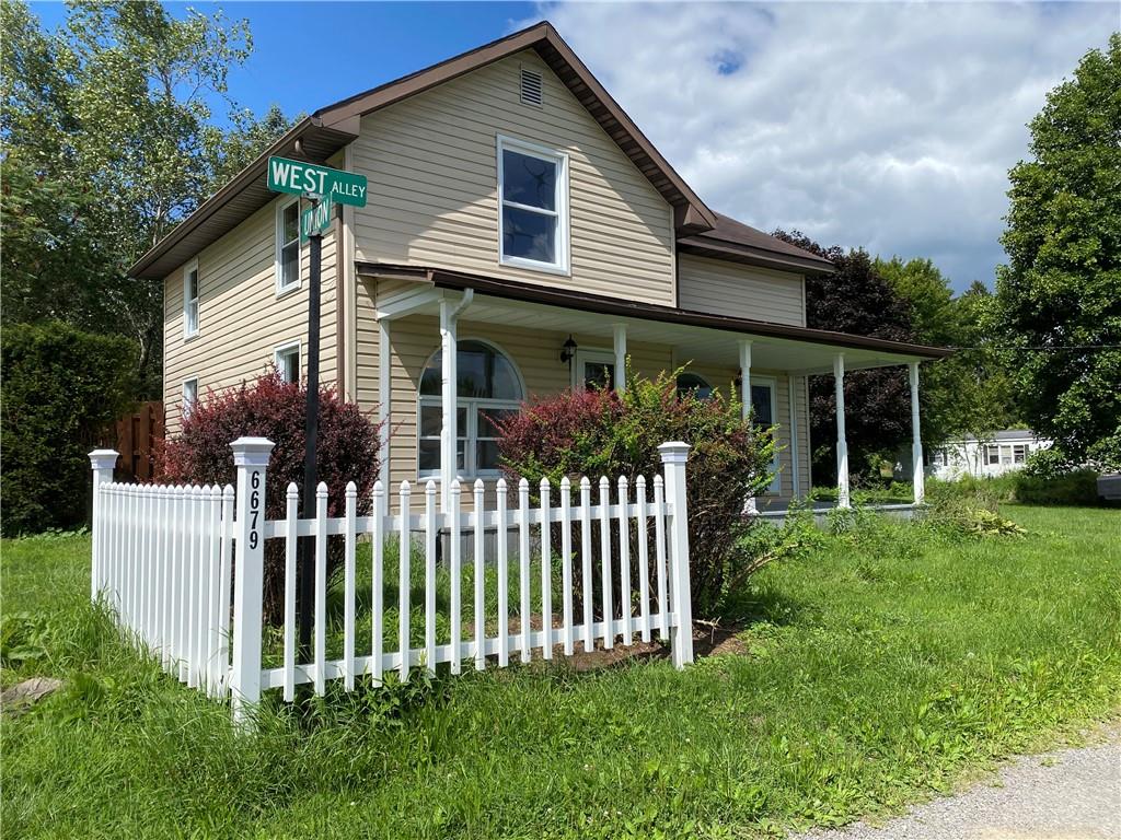 a front view of house with a garden