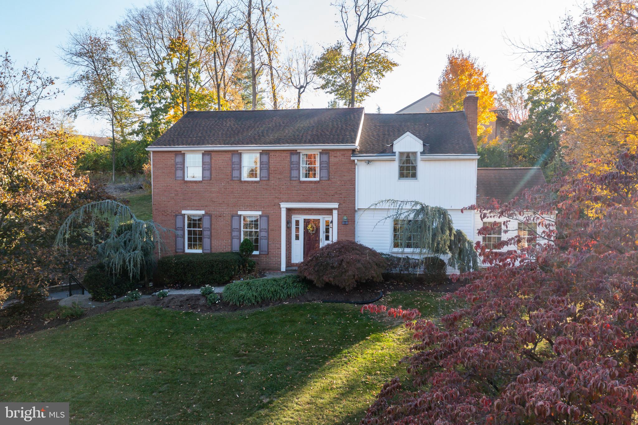 a front view of a house with a garden and trees