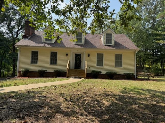 New england style home with a front lawn