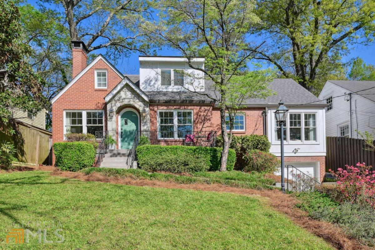 a front view of a house with a yard and trees