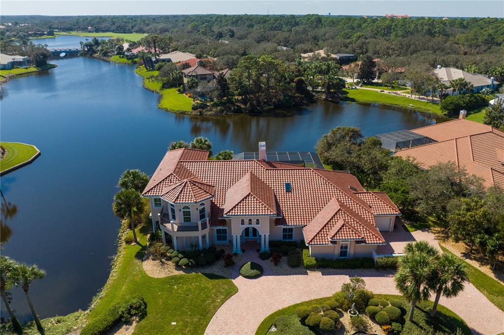 an aerial view of a house with swimming pool and lake view