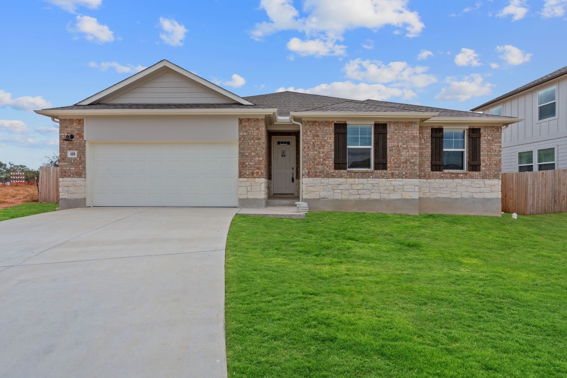 a front view of a house with a yard and garage