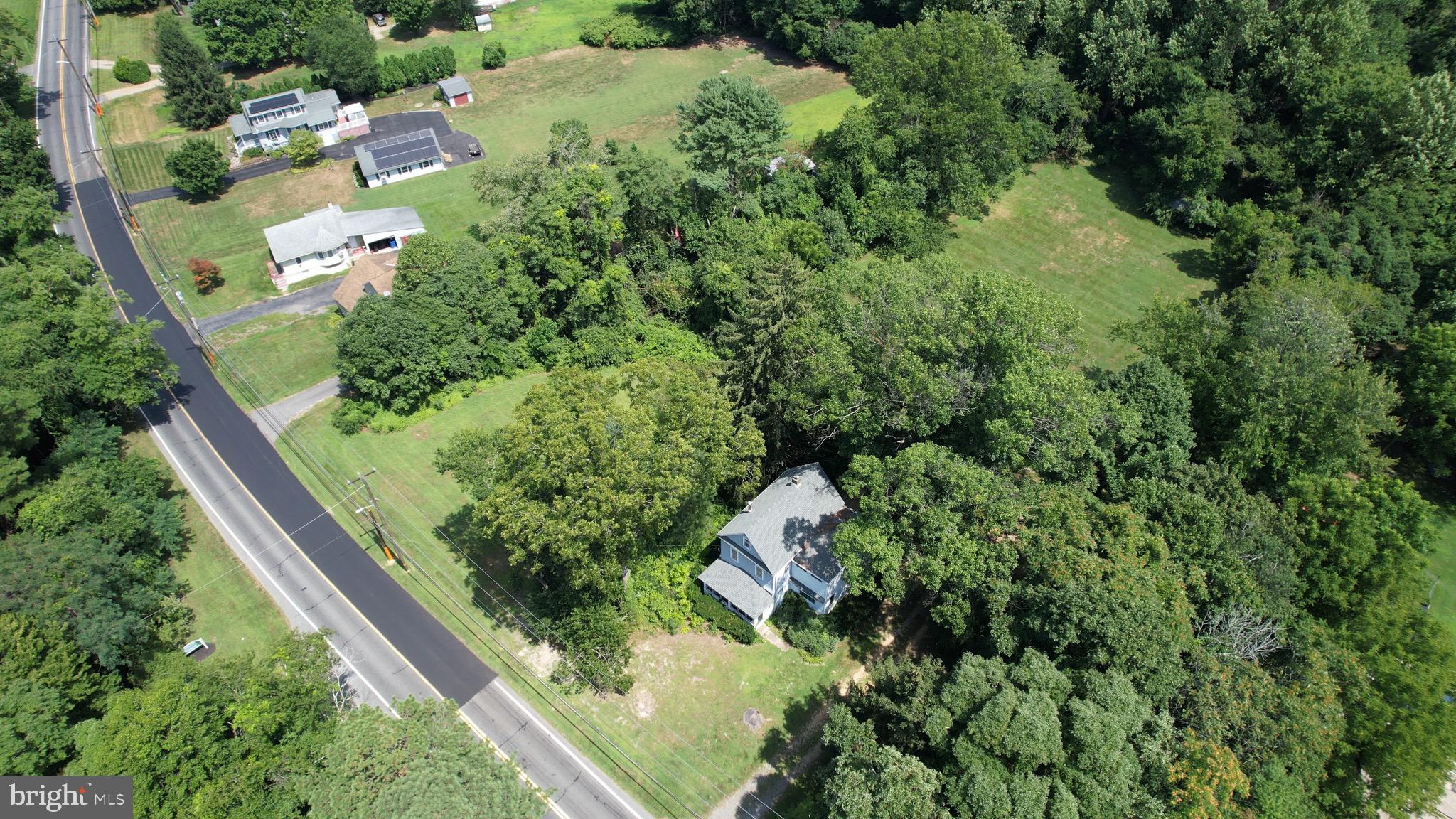 an aerial view of residential house with outdoor space and trees all around