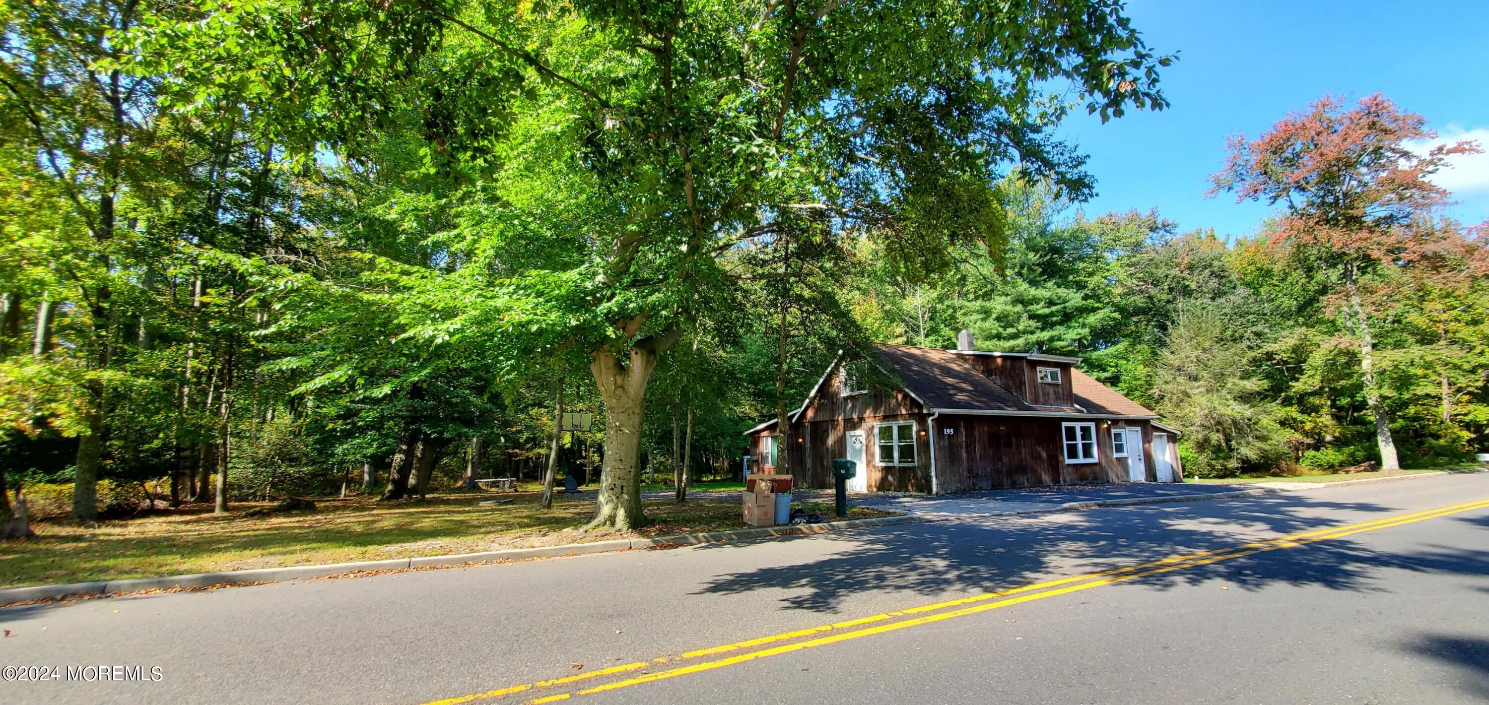 a front view of a house with a yard and large trees