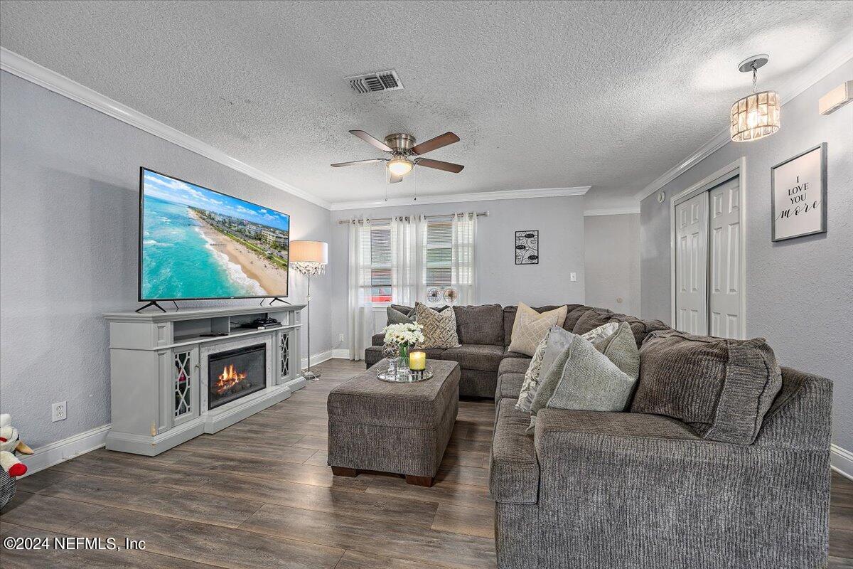 a living room with furniture a flat screen tv and a fireplace