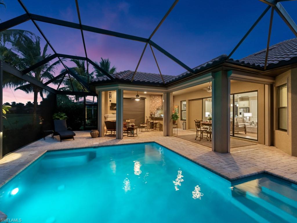 Pool at dusk featuring entertainment areas,and a covered  lanai.