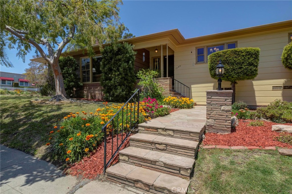 a front view of a house with a yard and potted plants