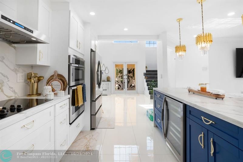 a kitchen with stainless steel appliances a sink a stove a refrigerator and cabinets