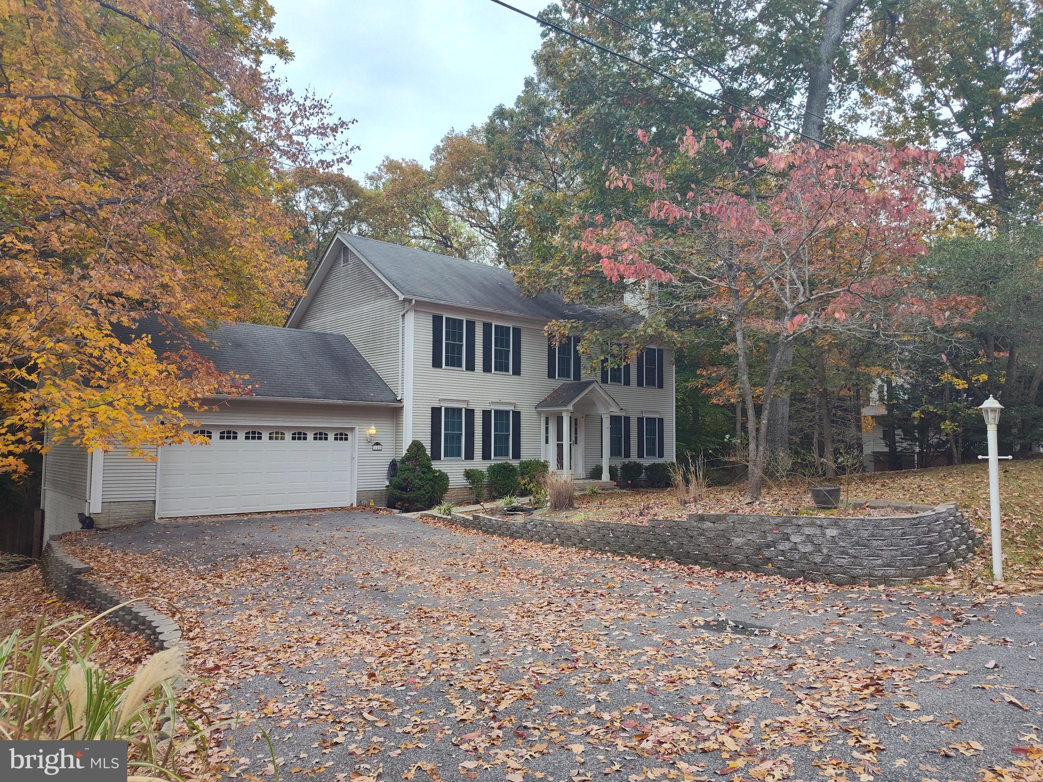 a front view of a house with a yard and trees