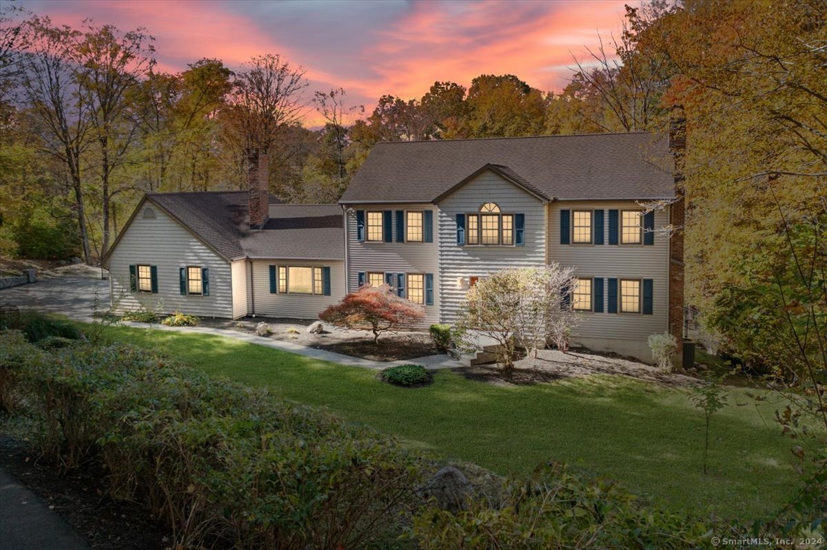 a front view of a house with yard and green space