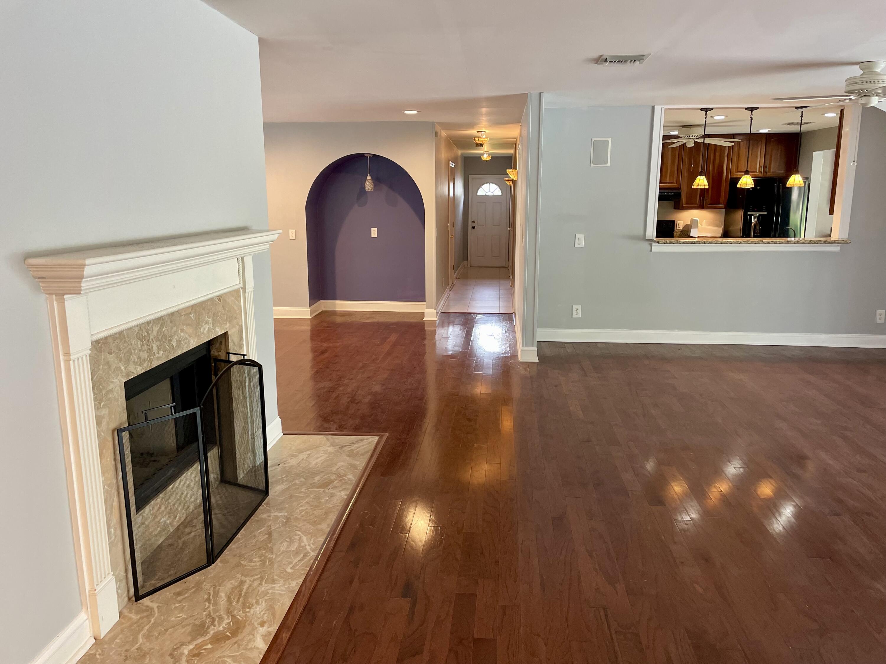 a view of a livingroom with wooden floor and a fireplace